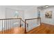 Bright hallway features hardwood floors, white walls, natural light, and wooden railings at 5334 Lake View Clb, Atlanta, GA 30338