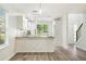 Bright kitchen featuring an eat-in bar, stainless steel appliances, and gray wood-look flooring at 3527 Clare Cottage Sw Trce, Marietta, GA 30008