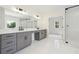 Modern bathroom with double vanity, large mirrors, gray cabinetry, and a glass enclosed shower at 3930 Clifton Hill Court #15, Cumming, GA 30040