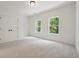 Light-filled bedroom with two large windows, neutral carpet, and a double door closet at 3930 Clifton Hill Court #15, Cumming, GA 30040