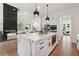 Modern open-concept kitchen features an island with countertop seating and views of the living area at 3930 Clifton Hill Court #15, Cumming, GA 30040