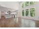 Bright living room featuring a modern kitchen, wall of windows, and open floor plan at 3930 Clifton Hill Court #15, Cumming, GA 30040