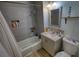 Bathroom with gray tiled shower-tub and vanity with modern fixtures at 493 James Street Sw, Lilburn, GA 30047