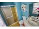 Bathroom featuring a sink, toilet, glass shower, and window at 493 James Street Sw, Lilburn, GA 30047