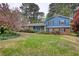 Charming two-story home with a brick facade, blue siding, and a well-manicured lawn with mature trees at 493 James Street Sw, Lilburn, GA 30047