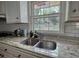 Kitchen sink with granite countertops and a window offering natural light at 493 James Street Sw, Lilburn, GA 30047