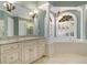 Lavish bathroom featuring tile flooring, columns, chandeliers and a large tub at 1418 Brighton Pl, Loganville, GA 30052