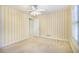 Bedroom with window with white shutters and bright yellow striped wallpaper at 1418 Brighton Pl, Loganville, GA 30052
