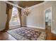 Formal dining room features elegant lighting, large window, and view into kitchen at 1418 Brighton Pl, Loganville, GA 30052