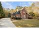 A stunning brick home features a manicured lawn, a driveway, and lush trees at 1418 Brighton Pl, Loganville, GA 30052