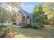 Charming brick home featuring an arched entryway and professionally landscaped front yard with mature trees at 1418 Brighton Pl, Loganville, GA 30052