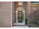 The entryway is framed by brick, featuring a decorative glass door and elegant lighting at 1418 Brighton Pl, Loganville, GA 30052