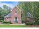 Brick home with a manicured lawn and mature trees creating a lush backdrop at 1418 Brighton Pl, Loganville, GA 30052
