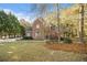 Charming two-story brick home featuring a well-manicured lawn and mature trees at 1418 Brighton Pl, Loganville, GA 30052