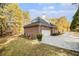 A large driveway leading to attached two-car garage with mature landscaping at 1418 Brighton Pl, Loganville, GA 30052