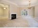 Open living area with fireplace, large window, and elegant chandelier at 1418 Brighton Pl, Loganville, GA 30052