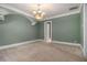 Living room with soft green walls, white crown moulding, and ceiling fan with chandelier at 1418 Brighton Pl, Loganville, GA 30052