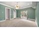 Living room with soft green walls, white crown moulding, and arched door to another room at 1418 Brighton Pl, Loganville, GA 30052