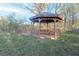 Wooden gazebo with built-in seating and table on a grassy lawn at 144 Morning Creek Rd, Jonesboro, GA 30238