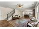Open-concept living room boasts hardwood floors, ceiling fan, staircase, and is connected to the kitchen area at 2251 Everleigh Ln, Marietta, GA 30064