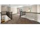 The spacious loft features neutral colored carpet, decorative metal railings, and lots of natural light from large windows at 2251 Everleigh Ln, Marietta, GA 30064