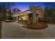 Backyard stone patio with a covered outdoor kitchen, stone fireplace, and hot tub surrounded by a wooden fence and trees at 2251 Everleigh Ln, Marietta, GA 30064