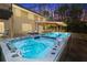Large hot tub and pool attached to a two-story home with outdoor lounge chairs and an outdoor kitchen at 2251 Everleigh Ln, Marietta, GA 30064