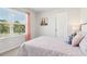 This bedroom is decorated with a pink quilt, curtains and a matching nightstand lamp at 3623 Squires Park Ln, Loganville, GA 30052