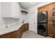 Functional laundry room featuring stacked washer/dryer and white custom cabinetry at 542 Orme Ne Cir, Atlanta, GA 30306