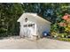 A charming outbuilding/garage with white siding, black trim, and beautiful landscaping creating a serene setting at 542 Orme Ne Cir, Atlanta, GA 30306