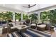 Covered outdoor patio with a sofa, chairs, ceiling fan and views to the backyard at 542 Orme Ne Cir, Atlanta, GA 30306