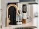 Close up of kitchen sink with white countertops and a gold faucet with a coffee maker in background at 542 Orme Ne Cir, Atlanta, GA 30306