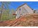 Exterior view of the house with sloping backyard and surrounding trees, providing privacy at 705 Sunset Ridge Se Ln, Lawrenceville, GA 30045