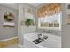 Bright bathroom with a large soaking tub, decorative window treatment, and stylish decor at 705 Sunset Ridge Se Ln, Lawrenceville, GA 30045