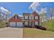 Inviting two-story brick home with an attached two-car garage and manicured lawn at 705 Sunset Ridge Se Ln, Lawrenceville, GA 30045