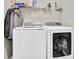 Laundry room with front load white washer and dryer and wire shelving at 705 Sunset Ridge Se Ln, Lawrenceville, GA 30045