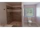 Modern bathroom showcasing a tiled shower with glass door and a toilet near the window at 170 Shoal Park Dr, Mcdonough, GA 30252