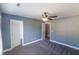 Bedroom with 2 white paneled doors, neutral blue walls, plush carpeting and ceiling fan at 170 Shoal Park Dr, Mcdonough, GA 30252