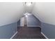 Angled attic bedroom with blue accent walls, neutral carpeting, and door into the hallway at 170 Shoal Park Dr, Mcdonough, GA 30252
