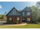 Two-story brick home featuring a manicured lawn, black shutters, and a gabled roof at 170 Shoal Park Dr, Mcdonough, GA 30252
