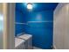 Bright laundry room with blue walls, shelving, and modern washer and dryer at 170 Shoal Park Dr, Mcdonough, GA 30252