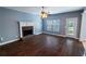 Living room with hardwood floors, a brick fireplace, and natural light through the window at 170 Shoal Park Dr, Mcdonough, GA 30252