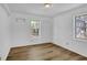 Bright bedroom featuring wood-look flooring and two windows for natural light at 455 Tyson Cir, Roswell, GA 30076