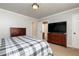 Cozy bedroom with a plaid bedspread, a television on a dresser, and neutral walls at 4960 Old Yorkville Rd, Dallas, GA 30157