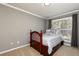 Comfortable bedroom with a wood-frame bed, soft gray bedding, and a bright window at 4960 Old Yorkville Rd, Dallas, GA 30157