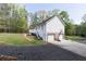 View of home's rear exterior featuring a 2-car garage, basketball hoop, covered patio, and additional garage at 4960 Old Yorkville Rd, Dallas, GA 30157