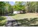 Charming home with a well-manicured front yard, mature trees, and a long driveway for ample parking at 4960 Old Yorkville Rd, Dallas, GA 30157