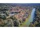 Enjoy a spectacular aerial view of the Chattahoochee River winding behind a lush wooded community at 295 Sagamore Nw Cv, Sugar Hill, GA 30518
