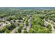 Aerial view of a neighborhood featuring homes surrounded by lush greenery and mature trees at 295 Sagamore Nw Cv, Sugar Hill, GA 30518