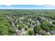 Aerial view of a residential area showcasing well-maintained homes amidst lush green trees at 295 Sagamore Nw Cv, Sugar Hill, GA 30518